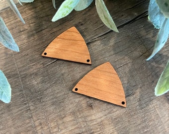 May include: Two unfinished wooden triangle shapes with holes for hanging. The triangles are on a woodgrain surface.