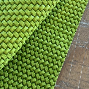 May include: Green woven fabric with a textured, raised pattern. The fabric has a soft, plush feel.