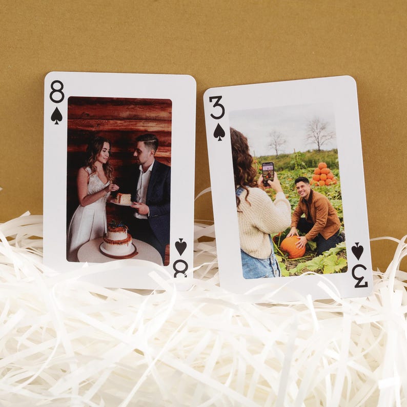 Puede incluir: Dos cartas de juego con fotos personalizadas. Una carta es el ocho de picas, que muestra a una pareja cortando un pastel. La otra es el tres de picas, con una persona tomando una foto de un hombre con una calabaza.