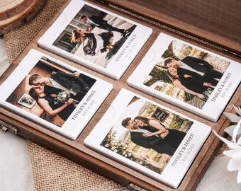 Puede incluir: Una caja de madera oscura que contiene cuatro juegos de tarjetas rectangulares blancas, cada una con una fotografía diferente de una pareja y el texto impreso TINSLEY & JAMES JULY 28, 2027. Las tarjetas están dispuestas en una cuadrícula.