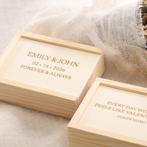 Puede incluir: Dos cajas de madera de color claro con texto grabado. La caja superior dice "EMILY & JOHN 02.14.2026 FOREVER & ALWAYS." La caja inferior dice "EVERY DAY WIT FEELS LIKE VALENT JASON XOXO."