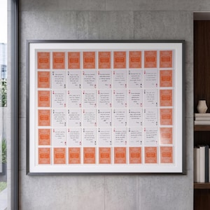 May include: A framed wall art piece featuring a grid of playing cards. The border consists of orange cards with a decorative pattern, while the inner cards contain handwritten notes and messages. The display is arranged in a rectangular format.