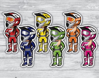 May include: Six colorful motocross rider stickers with helmets and goggles. Each sticker features a different color scheme, including red, blue, yellow, green, orange, and pink.