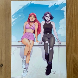Può includere: Due donne, una con i capelli rosa e un vestito rosa, l'altra con i capelli neri e un vestito nero, sono sedute su un muro bianco con uno sfondo di cielo blu.