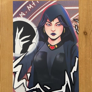 Può includere: Un'illustrazione digitale di una donna con capelli viola scuro che indossa un mantello nero con cappuccio e un gioiello rosso sul petto. Lo sfondo è viola scuro e grigio con linee bianche e il testo "I AM" in bianco.