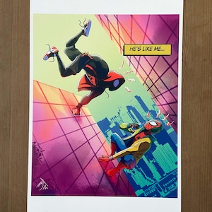 Può includere: Due personaggi di Spider-Man in un'illustrazione in stile fumetto. Uno è in un costume rosso e nero con cappuccio, l'altro è in un costume rosso e blu con una giacca gialla. Lo sfondo è uno skyline cittadino con un motivo a griglia. Il testo nella nuvoletta dice "È come me..."