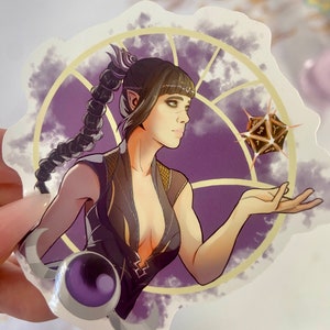 Può includere: Un adesivo con una donna con i capelli viola e un vestito scuro, che tiene un dado luminoso a più facce in una cornice circolare viola e dorata.