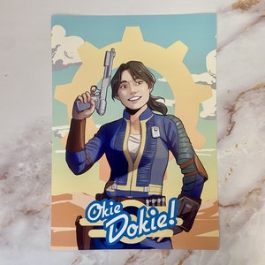 Può includere: Una donna in una tuta blu con una canottiera gialla e una pistola in mano. È in piedi davanti a un ingranaggio giallo su uno sfondo blu. Il testo "Okie Dokie!" è scritto in bianco, blu e giallo.
