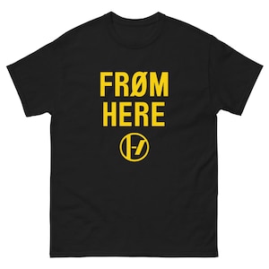 May include: Black t-shirt featuring the yellow text "FROM HERE" and a yellow circular logo with a "1-7" design. The shirt is made from a heavy-weight fabric, suitable for everyday wear.