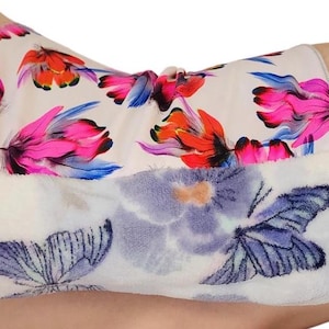 May include: A white and pink floral print fabric with a white and blue butterfly print on the reverse side. The fabric is soft and plush.