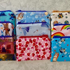 Puede incluir: Una colección de diez pequeñas bolsas con cremallera de varios patrones coloridos. Las bolsas presentan personajes de programas infantiles populares, como Frozen de Disney, La Patrulla Canina y Bluey.