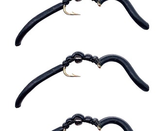 May include: Three black rubber fly fishing lures with gold hooks and a black bead on each lure.