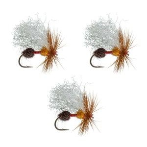 May include: Three brown and white fly fishing lures with white feathers and brown and yellow accents.