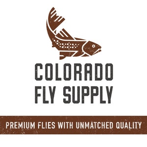 May include: A brown silhouette of a trout fish with a white outline. The text "COLORADO FLY SUPPLY" is below the fish in black. The text "PREMIUM FLIES WITH UNMATCHED QUALITY" is below the text in brown.
