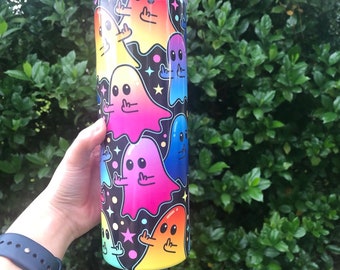 May include: A stainless steel tumbler with a black background and a pattern of colorful ghosts giving the middle finger. The ghosts are in shades of pink, yellow, blue, and orange.