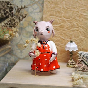 Goat with freckles, miniature clay figurine,  goat in dress figure, rural style, desk pet sculpted, cute cartoon animals, cottagecore