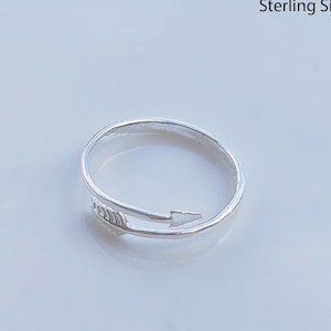 May include: A silver ring with a simple arrow design. The ring is handcrafted from sterling silver.