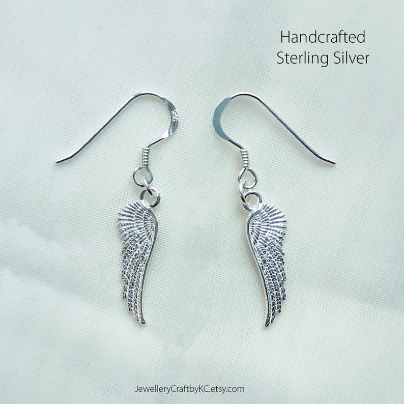 Puede incluir: Un par de pendientes de plata con un dise&ntilde;o de ala detallado. Los pendientes est&aacute;n hechos a mano en plata de ley.