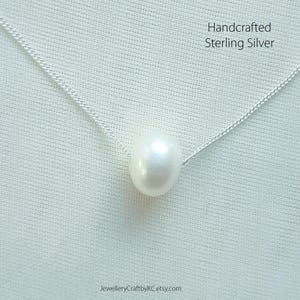 May include: A single white pearl pendant necklace on a sterling silver chain. Handcrafted Sterling Silver.