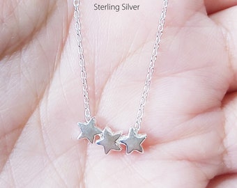 May include: A silver necklace with three small star charms. The necklace is handcrafted from sterling silver.