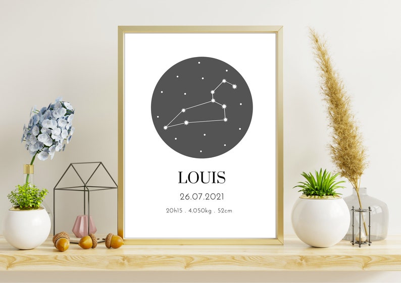 May include: A framed print with a gold border displays a Leo constellation graphic in white on a dark gray circle. The name "LOUIS" is below, along with the date 26.07.2021, time, weight, and height: 52cm.