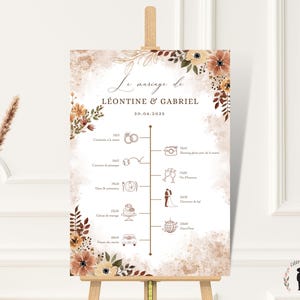 Peut inclure: Panneau de programme de mariage sur chevalet. Le texte "Le mariage de Léontine & Gabriel" et un programme illustré. Le design comprend des éléments floraux dans les tons marron, orange et crème.