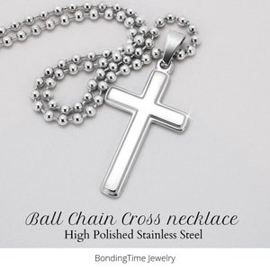 K&ouml;nnte beinhalten: Eine silberne Kugelkette mit einem hochglanzpolierten Edelstahl-Kreuzanh&auml;nger. Die Kette und der Anh&auml;nger sind gl&auml;nzend und reflektieren das Licht. Das Kreuz ist ein schlichtes Design mit leicht abgerundeten Kanten. Kugelkette Kreuz Halskette Hochglanzpolierter Edelstahl BondingTime Jewelry