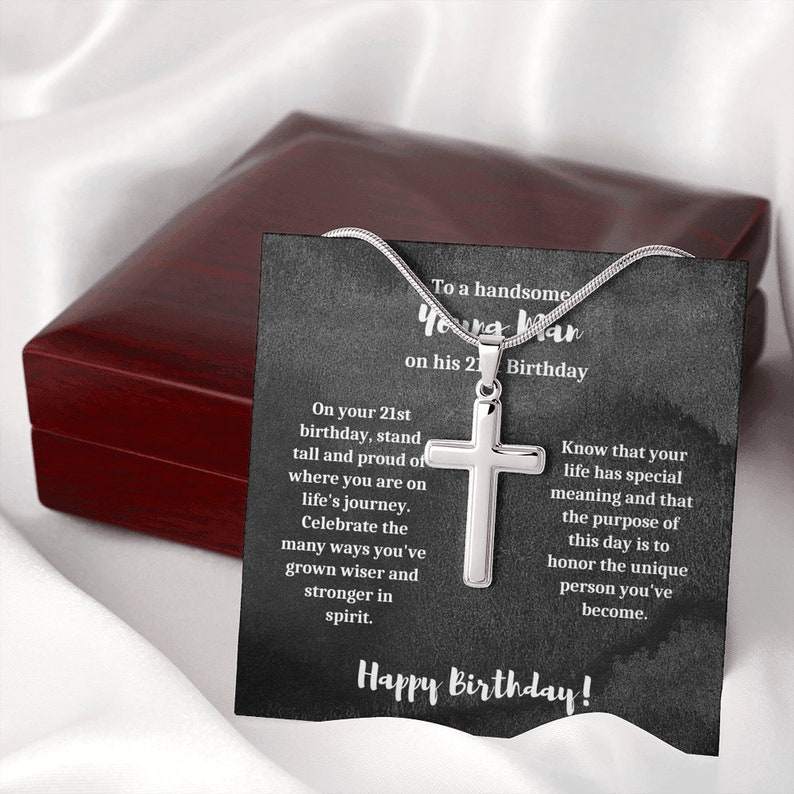 K&ouml;nnte beinhalten: Eine silberne Kreuzkette in einer schwarzen Geschenkbox mit einer Karte, auf der steht "An einen gutaussehenden jungen Mann zu seinem 21. Geburtstag". Die Karte enth&auml;lt eine Botschaft, die lautet: "Zu deinem 21. Geburtstag, stehe stolz und gerade da, wo du auf deiner Lebensreise bist. Feiere die vielen Wege, auf denen du kl&uuml;ger und st&auml;rker im Geiste geworden bist. Wisse, dass dein Leben eine besondere Bedeutung hat und dass der Sinn dieses Tages darin besteht, die einzigartige Person zu ehren, die du geworden bist. Alles Gute zum Geburtstag!"