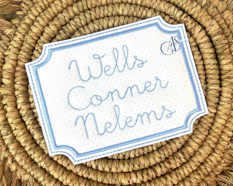 Puede incluir: Un letrero blanco bordado con un borde azul y lunares azules. El letrero dice "Wells Conner Nelms".