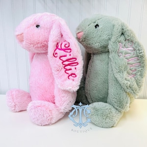 May include: Two plush bunny toys, one pink and one green, with the name "Lillie" embroidered on each.