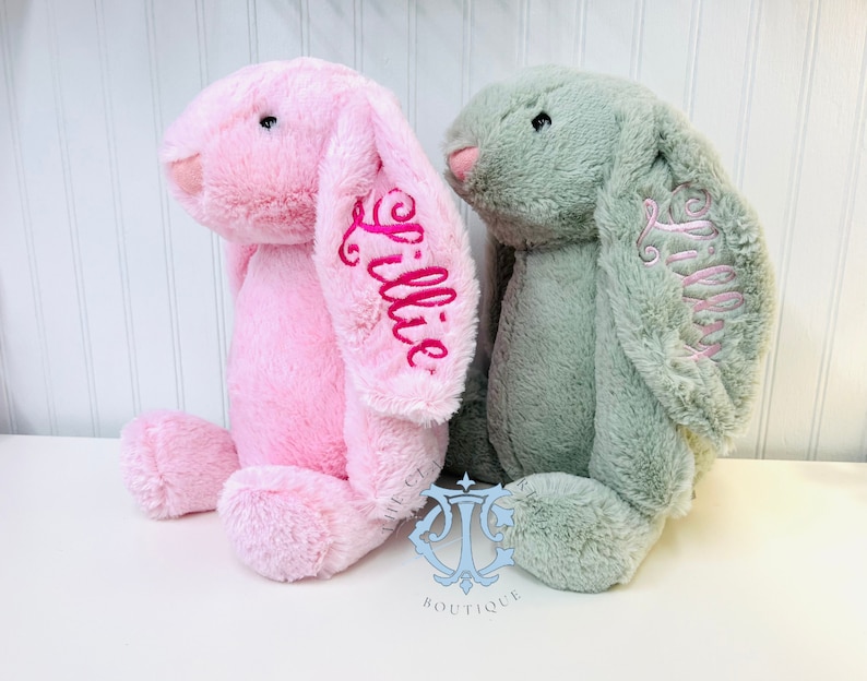 May include: Two plush bunny toys, one pink and one green, with the name "Lillie" embroidered on each.