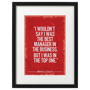 May include: A red framed print with a white background and a quote by Brian Clough. The quote reads, "I wouldn't say I was the best manager in the business. But I was in the top one."