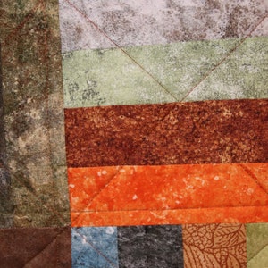 Puede incluir: Una colcha de retazos con una variedad de colores y patrones, incluyendo marr&oacute;n, naranja, verde y gris. La colcha est&aacute; hecha de diferentes telas y texturas, creando un dise&ntilde;o &uacute;nico e interesante.