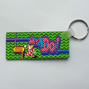 May include: Green keyring with a cartoon clown running and the text "Mr. Do!" in colourful letters. The text "Universal" is also visible on the keyring.