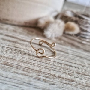 Peut inclure: Une bague en or avec un design unique et torsadé. La bague est faite de fil fin et a un look simple et élégant.