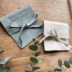 May include: Two small, fabric gift bags with a satin ribbon tie. The bags are light green and white. The bags are personalized with the text "To my beautiful bridesmaid".