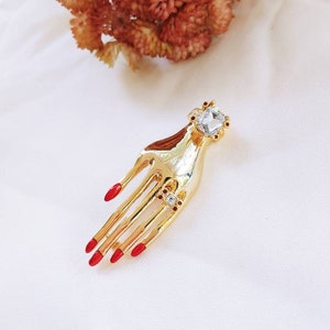 Vintage Gold Tone Hand Brooch: Rhinestone Ring, Red Nails