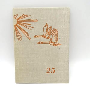 May include: A beige book cover with an orange illustration of a sun and two flying birds. The number 25 is printed in orange at the bottom. The cover has a textured appearance.