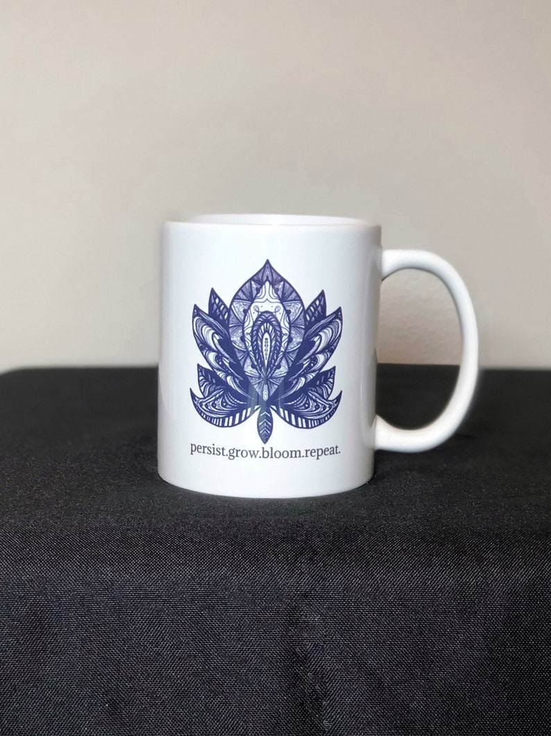 Peut inclure: Une tasse en c&eacute;ramique blanche avec un motif de mandala bleu et blanc et le texte "persist.grow.bloom.repeat."