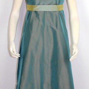 May include: A teal blue dress with a yellow sash and ruffles at the hem. The dress has short sleeves and a fitted bodice.