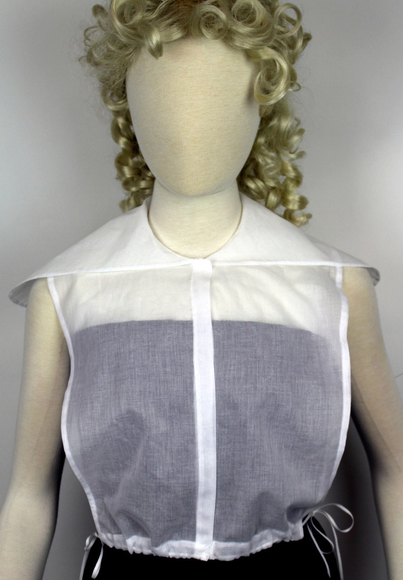 May include: A white sheer blouse with a large, detachable collar. The blouse has a button closure and a gathered hem.