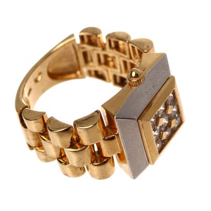 May include: A gold watch ring with a square face and a band that looks like a watch band. The face is set with small clear stones.