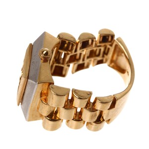 May include: A gold and silver watch ring with a square face and a band that resembles a watch band.