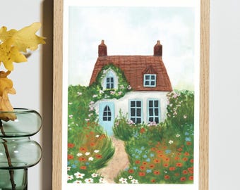 May include: A framed art print depicting a white cottage with a red roof, light blue doors and window frames, and two chimneys. The house is surrounded by a lush garden filled with red, white, and blue flowers, with a path leading to the front door.