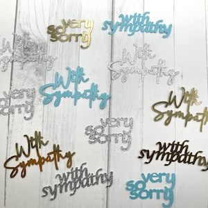 May include: Assortment of sympathy cards with glitter. The cards are in blue, gold, and silver. The cards say "With Sympathy", "Very Sorry", and "With Sympathy".