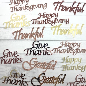 May include: A collection of gold and rose gold glitter Thanksgiving themed words, including "Happy Thanksgiving", "Give Thanks", "Thankful", and "Grateful".