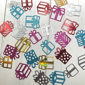 May include: Assortment of colorful glitter gift box confetti. The confetti is made of cardboard and features a variety of colors, including silver, gold, red, pink, blue, and green.