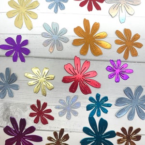 May include: Assortment of 18 die-cut paper flowers in various colors and metallic finishes. The flowers are all the same design, with six petals and a center circle. The colors include gold, silver, red, blue, purple, and green.