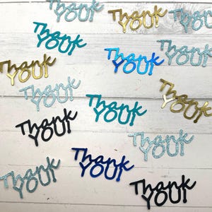 May include: Assortment of thank you confetti in various colors, including gold, blue, teal, and black. The confetti is made of glitter paper and has a handwritten font.