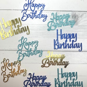 May include: Assortment of ten gold and blue glitter paper 'Happy Birthday' cake toppers. The toppers are in various sizes and styles.